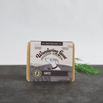 a bar of anise scented goat milk soap sits on a piece of slate with a green frond of fennel behind the soap.