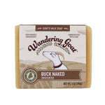 A bar of wrapped Wandering Goat Buck Naked Soap. The wrapper has the logo, goat head and banner that reads, "Buck Naked."